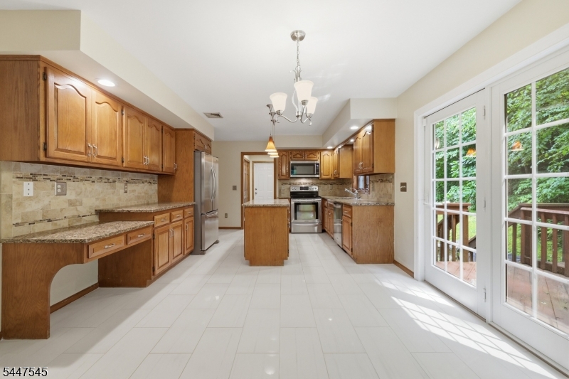 860 Glen Road Sparta, NJ 07871 - Photo 12 of 43 a kitchen with stainless steel appliances granite countertop a stove top oven a refrigerator a sink dishwasher a dining table and chairs with wooden floor