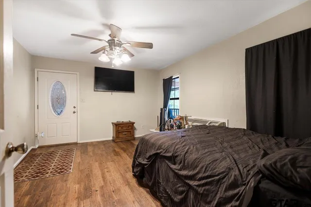 a spacious bedroom with a bed and wooden floor
