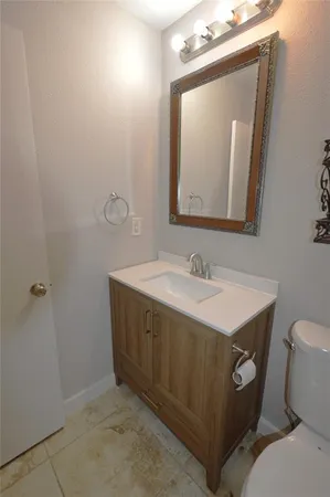 a bathroom with a sink vanity mirror and toilet