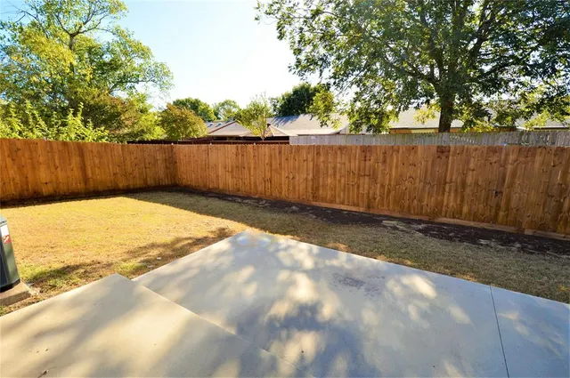 a view of backyard with wooden fence