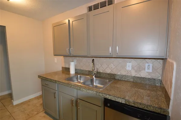a kitchen with granite countertop a sink and cabinets