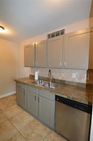 a kitchen with granite countertop a sink and cabinets
