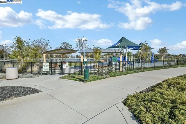 a backyard of a house with table and chairs under an umbrella