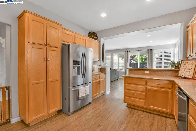 a kitchen with stainless steel appliances a refrigerator and wooden floor