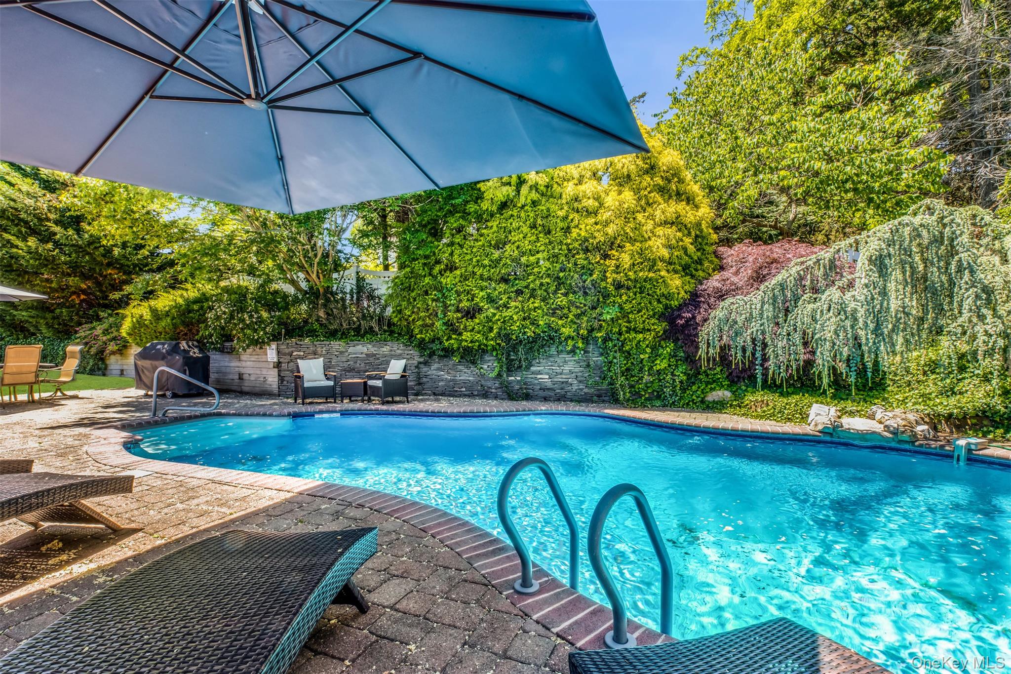 345 Colonial Road Southold, NY 11971 - Photo 35 of 43 a view of a backyard with table and chairs under an umbrella
