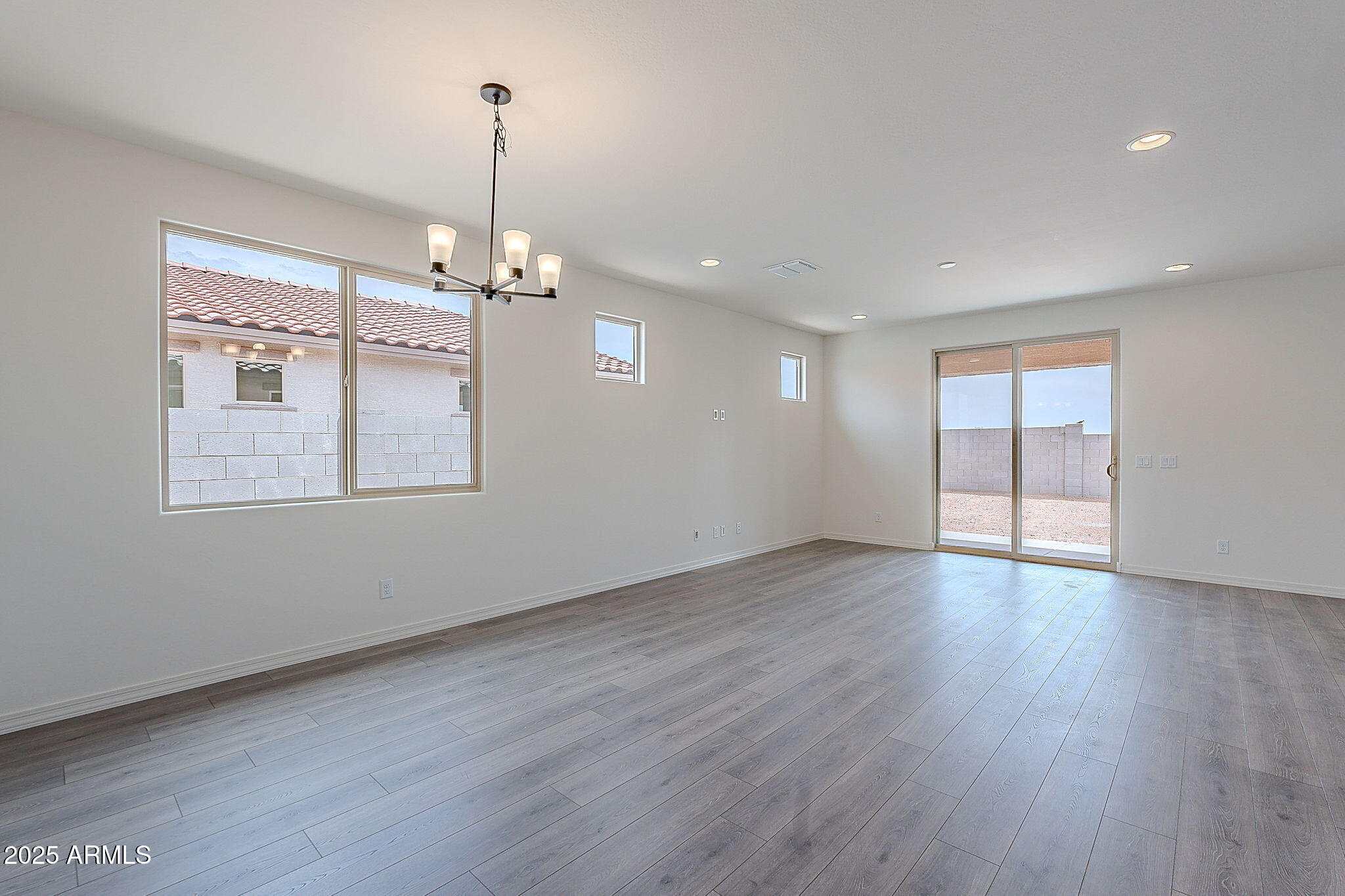 40025 Bunker Drive Maricopa, AZ 85138 - Photo 17 of 18 a view of a room with wooden floor exposed radiator and windows