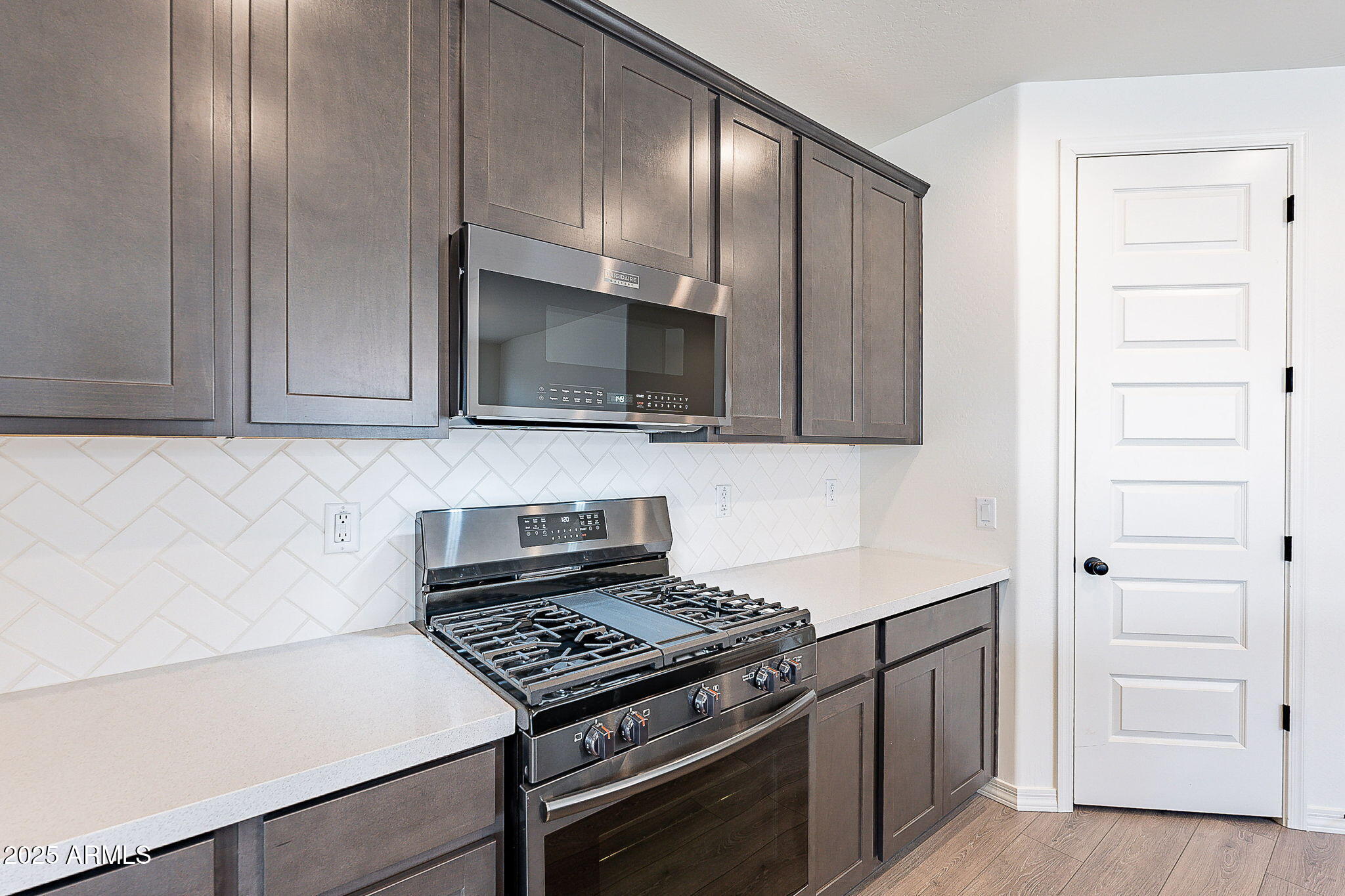 40025 Bunker Drive Maricopa, AZ 85138 - Photo 2 of 18 a kitchen with cabinets stainless steel appliances and wooden floor