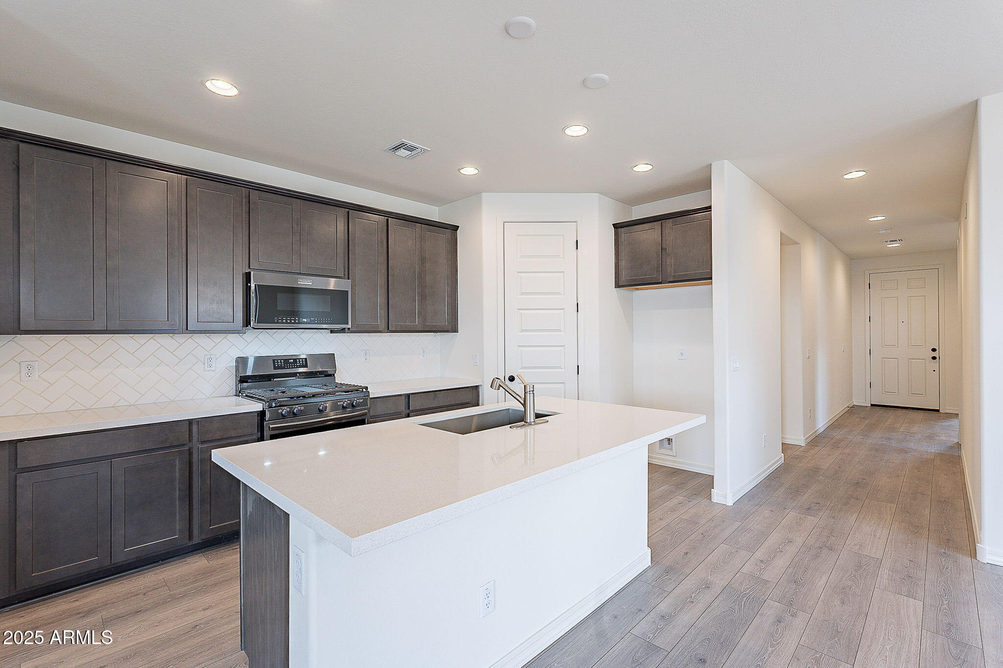 40025 Bunker Drive Maricopa, AZ 85138 - Photo 4 of 18 a kitchen with stainless steel appliances granite countertop a sink stove and refrigerator
