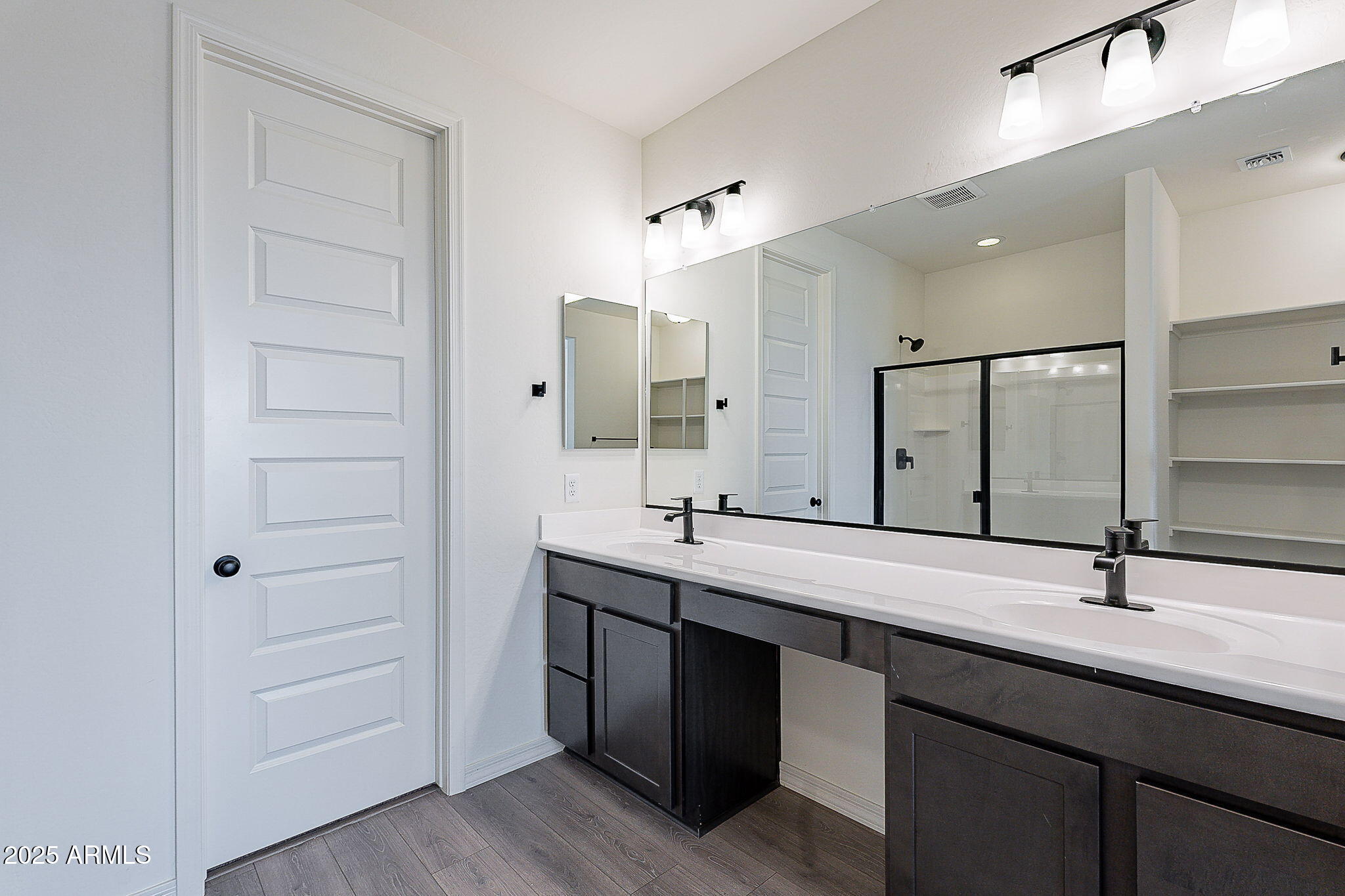 40025 Bunker Drive Maricopa, AZ 85138 - Photo 6 of 18 a bathroom with a double vanity sink a mirror and a bathtub
