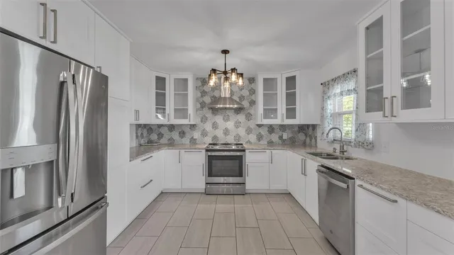 a kitchen with stainless steel appliances granite countertop a refrigerator and a stove top oven