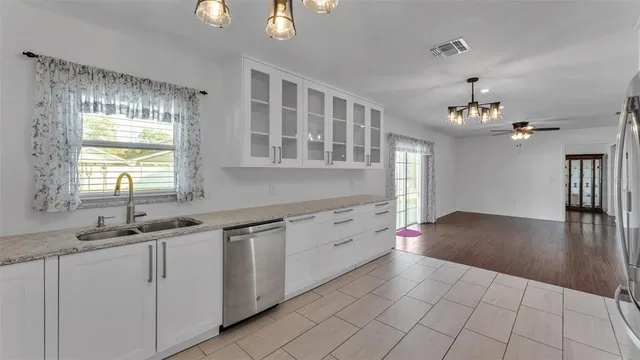 a kitchen with granite countertop a sink cabinets and wooden floor