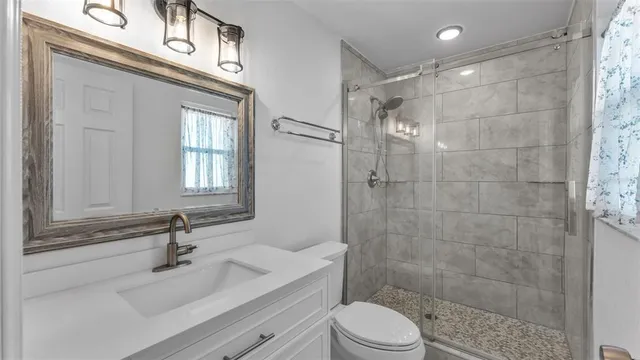 a bathroom with a sink a toilet and shower