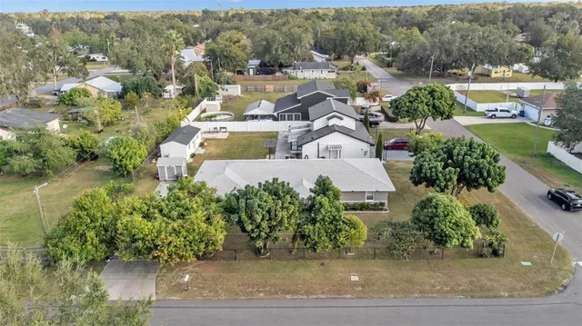 an aerial view of a house with yard and parking