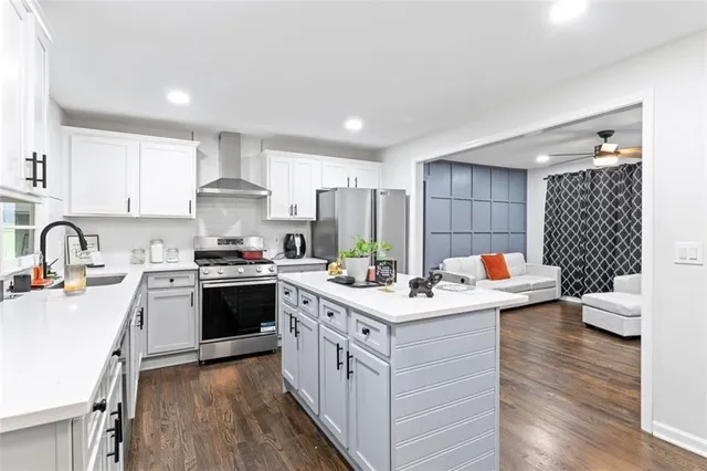 a kitchen with a sink stove cabinets and wooden floor