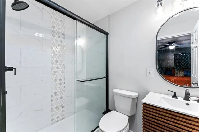 a bathroom with a sink a toilet and shower