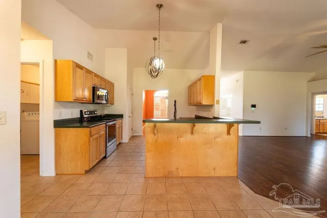 a view of kitchen with cabinets and window