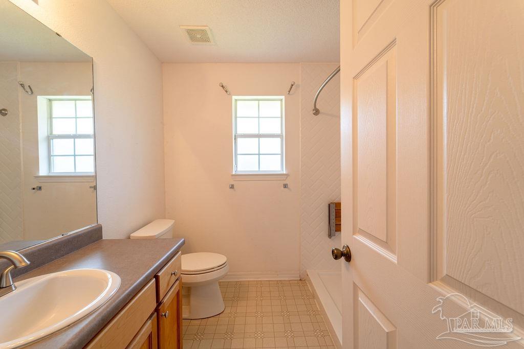 4907 Chads Circle Pace, FL 32571 - Photo 16 of 40 a bathroom with a sink toilet a mirror and shower