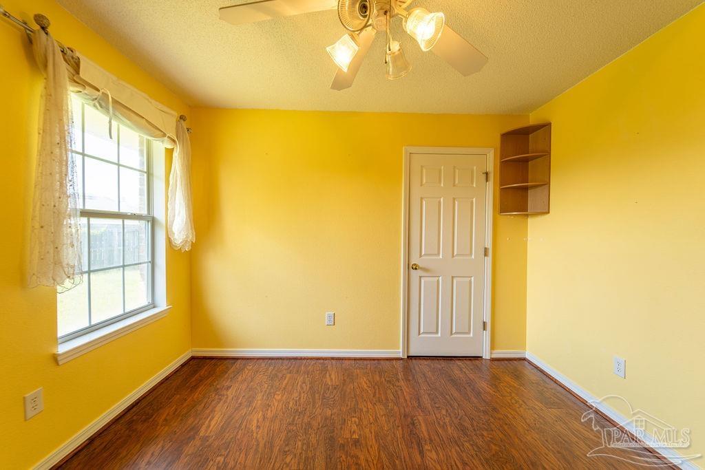 4907 Chads Circle Pace, FL 32571 - Photo 21 of 40 a view of an empty room with wooden floor and a window
