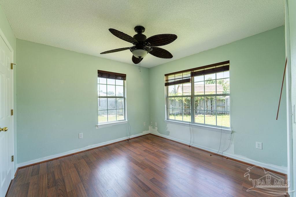 4907 Chads Circle Pace, FL 32571 - Photo 22 of 40 a view of an empty room with wooden floor and a window