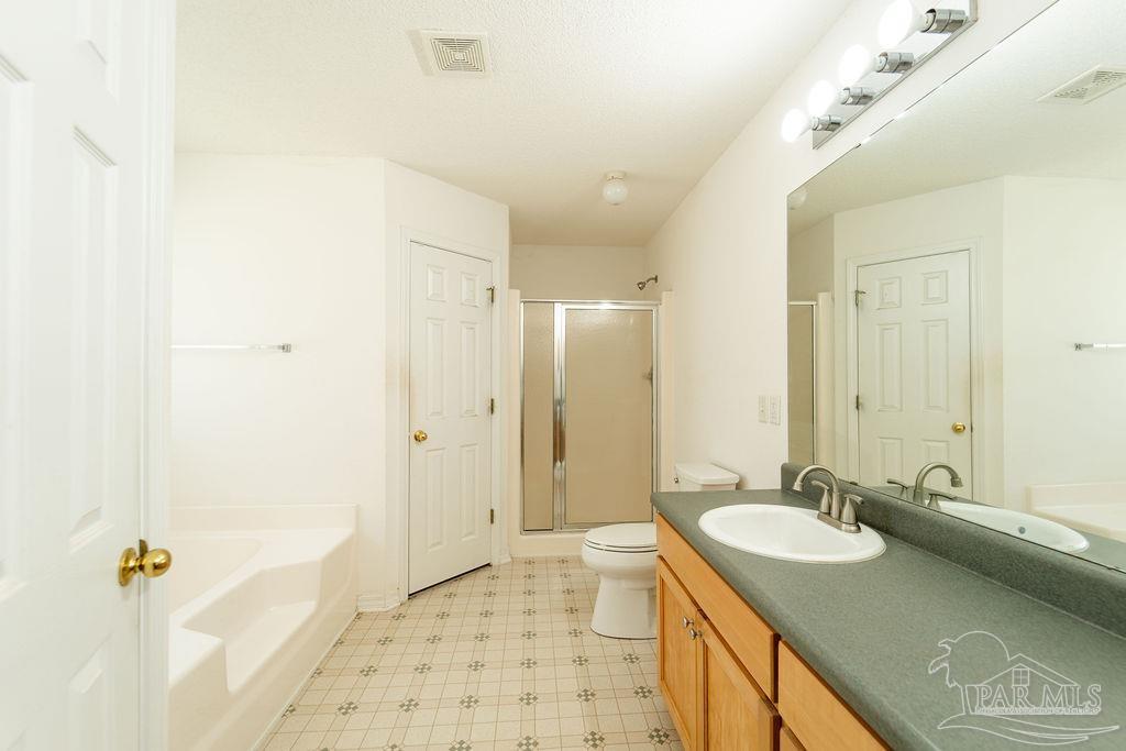 4907 Chads Circle Pace, FL 32571 - Photo 28 of 40 a bathroom with a granite countertop sink a mirror a shower and a bathtub