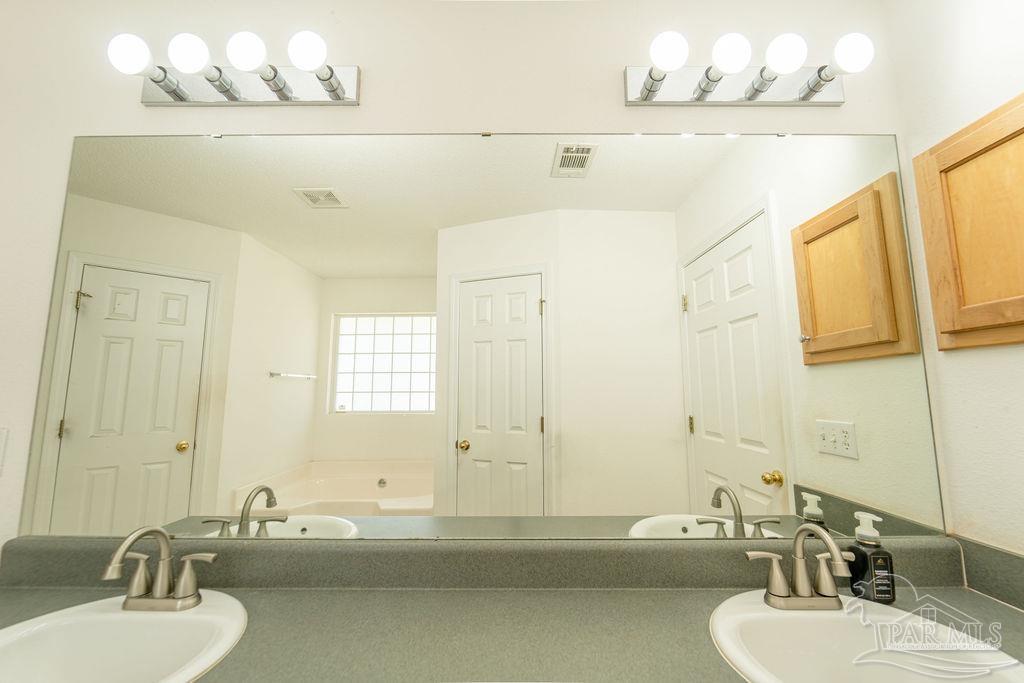 4907 Chads Circle Pace, FL 32571 - Photo 29 of 40 a bathroom with a sink a mirror and a bathtub
