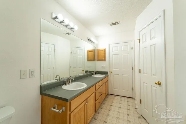 a bathroom with a sink double vanity granite tub shower and a mirror