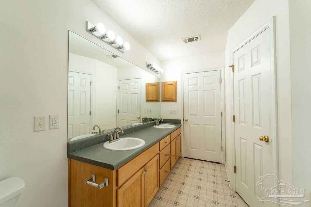 4907 Chads Circle Pace, FL 32571 - Photo 30 of 40 a bathroom with a sink double vanity granite tub shower and a mirror