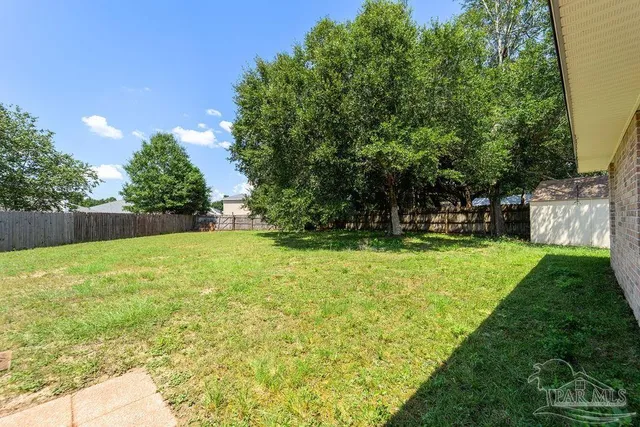 a view of yard with swimming pool and green space