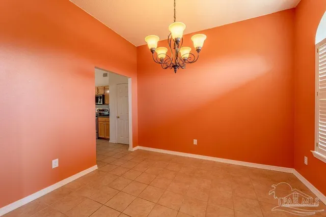 a view of a room with a hanging light and kitchen