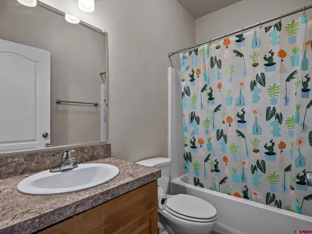 a bathroom with a granite countertop toilet a sink and a mirror