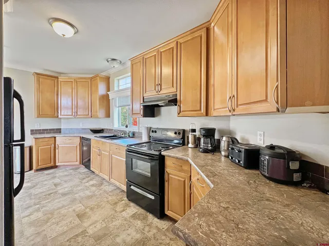 a kitchen with stainless steel appliances granite countertop a stove a sink dishwasher and a refrigerator