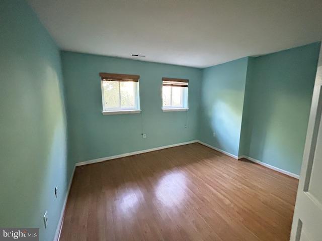 3 Windblown Court, Unit 102 Baltimore, MD 21209 - Photo 16 of 18 an empty room with wooden floor and windows