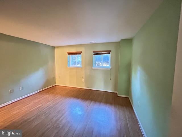 3 Windblown Court, Unit 102 Baltimore, MD 21209 - Photo 2 of 18 an empty room with wooden floor and windows