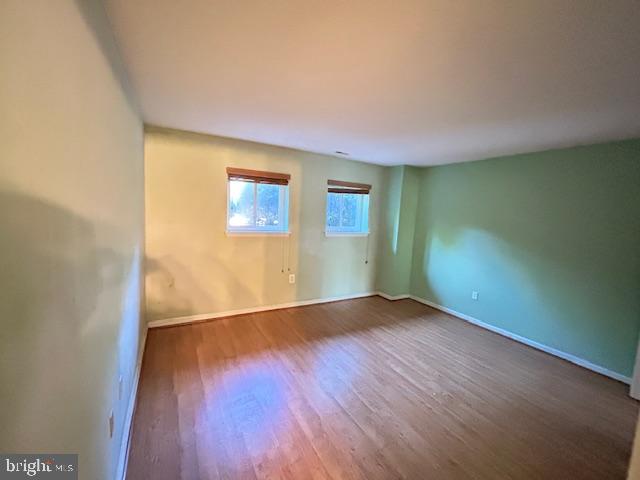 3 Windblown Court, Unit 102 Baltimore, MD 21209 - Photo 4 of 18 an empty room with wooden floor and windows