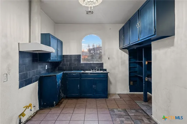 a large kitchen with lot of cabinets and stainless steel appliances