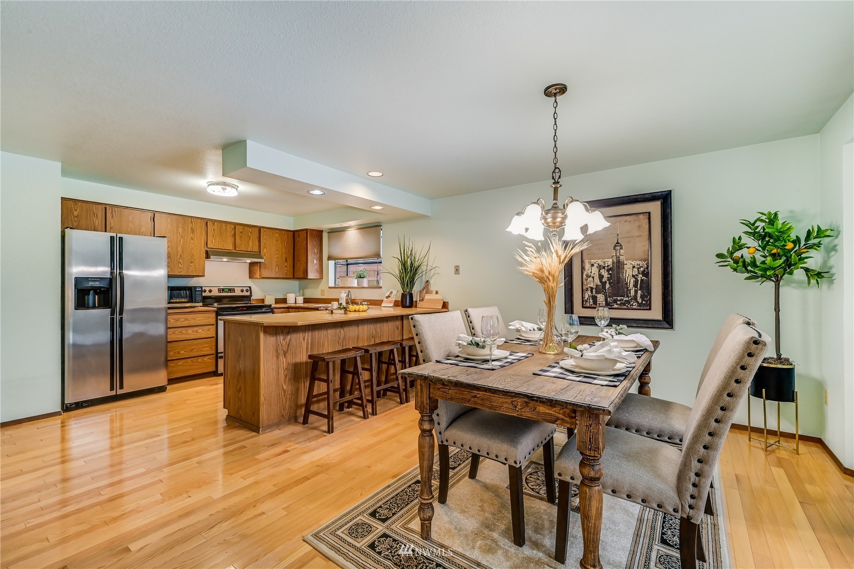 1217 225th Place Southwest Bothell, WA 98021 - Photo 8 of 21 a dining room with stainless steel appliances kitchen island granite countertop a dining table chairs and chandelier