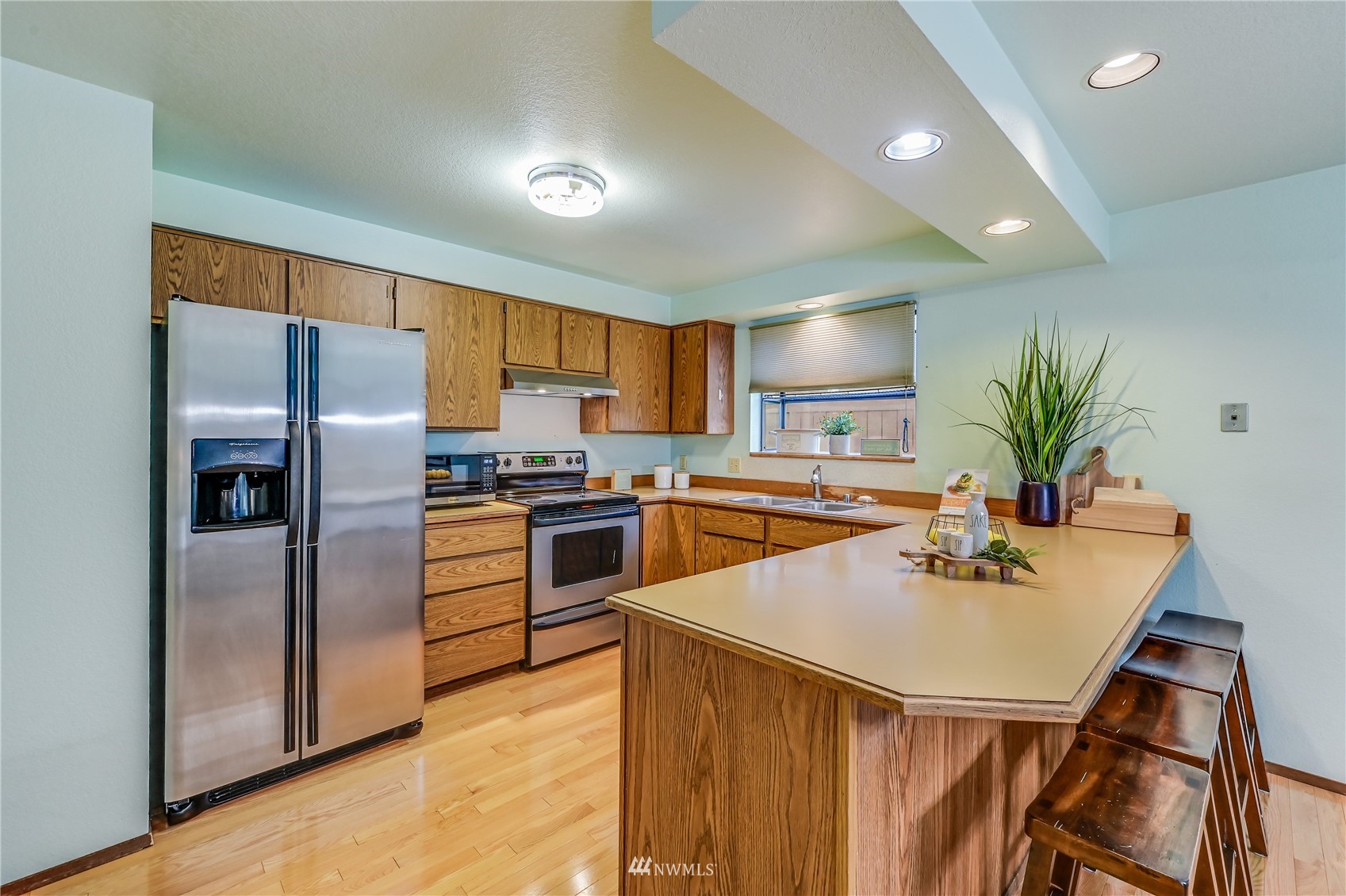 1217 225th Place Southwest Bothell, WA 98021 - Photo 9 of 21 a kitchen with a refrigerator a sink dishwasher and a stove with wooden floor