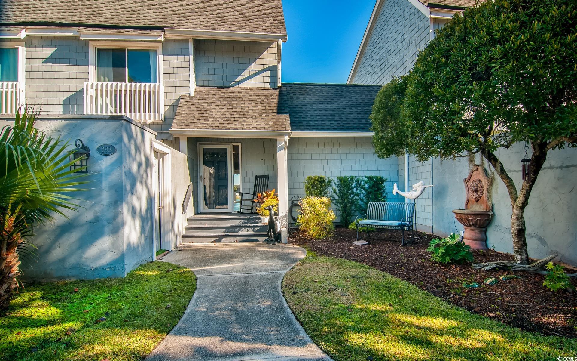 Doorway to property featuring roof with shingles
