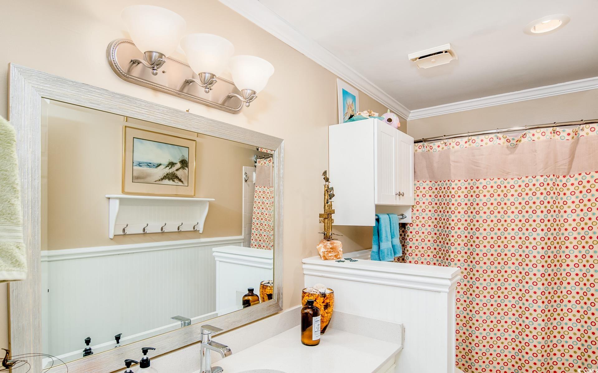 27 Pheasant Loop, Unit 293 Georgetown, SC 29440 - Photo 20 of 23 Full bathroom featuring vanity, a shower with curtain, wainscoting, and ornamental molding