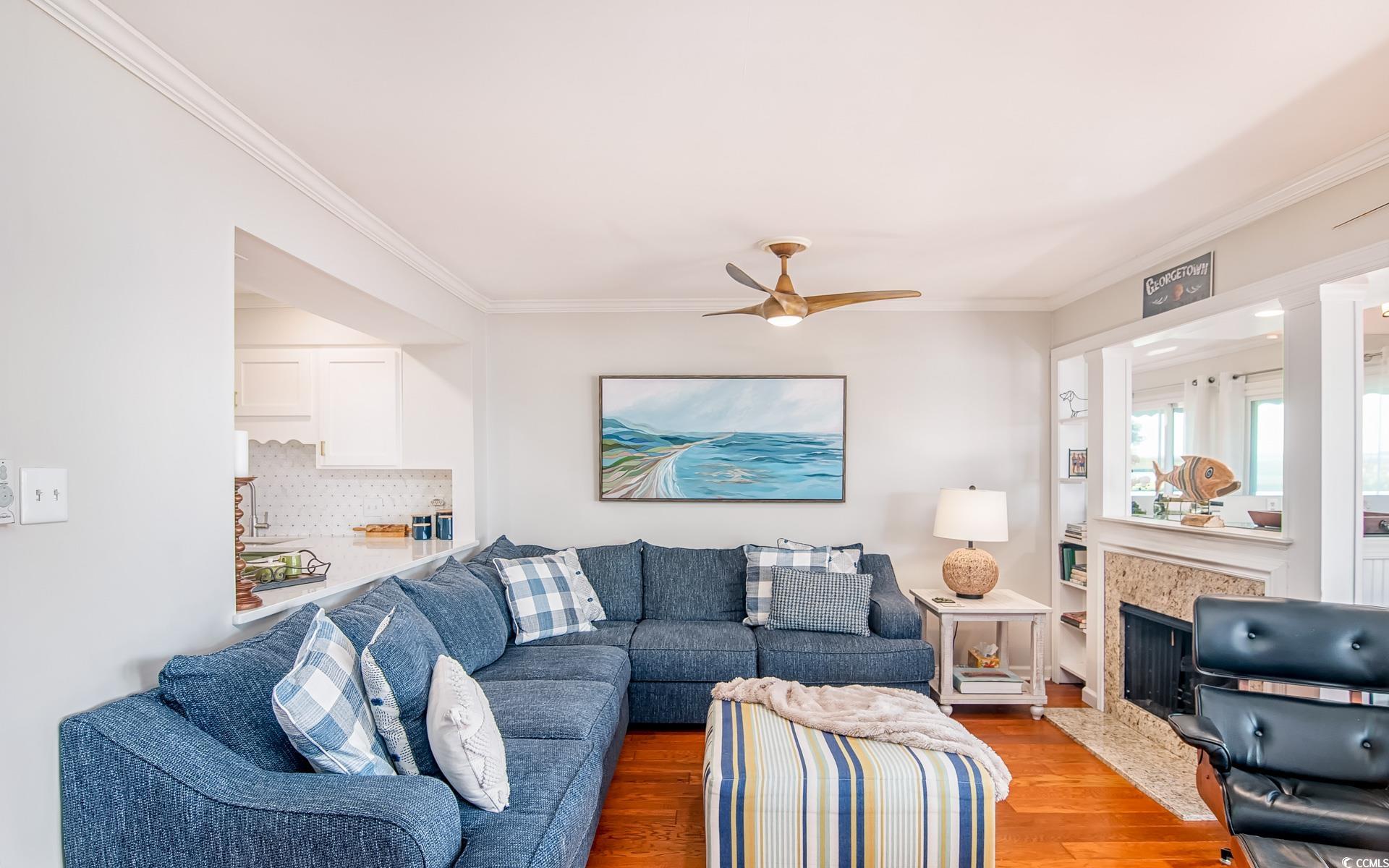 27 Pheasant Loop, Unit 293 Georgetown, SC 29440 - Photo 8 of 23 Living area featuring wood finished floors, ceiling fan, ornamental molding, and a fireplace