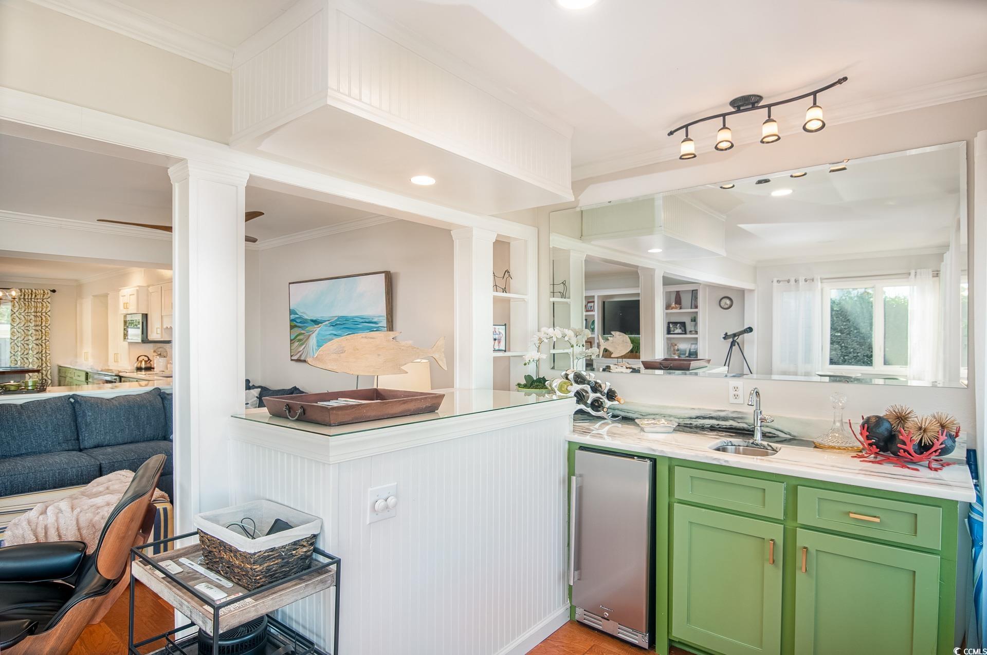 27 Pheasant Loop, Unit 293 Georgetown, SC 29440 - Photo 10 of 23 Bar area with ornamental molding, healthy amount of natural light, green cabinets, stainless steel fridge, and recessed lighting