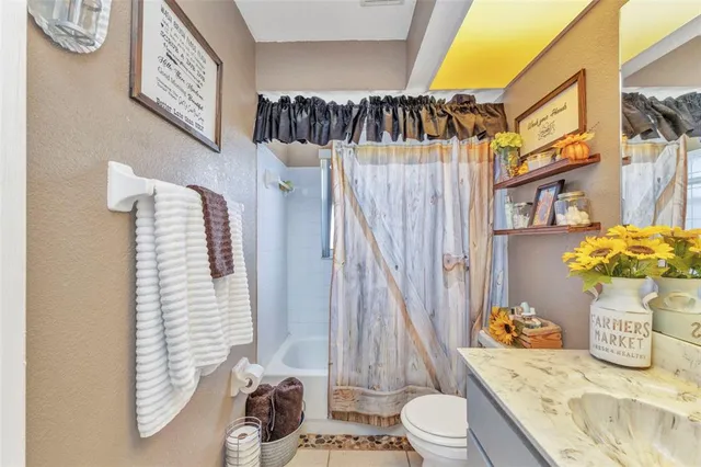 a bathroom with a sink a toilet and shower curtain