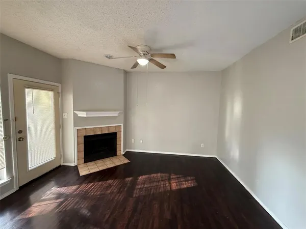 a view of empty room with wooden floor and fireplace