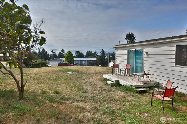 a view of a backyard with table and chairs and potted plants