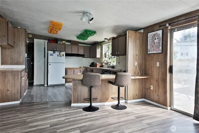 a kitchen with stainless steel appliances kitchen island granite countertop a refrigerator and cabinets