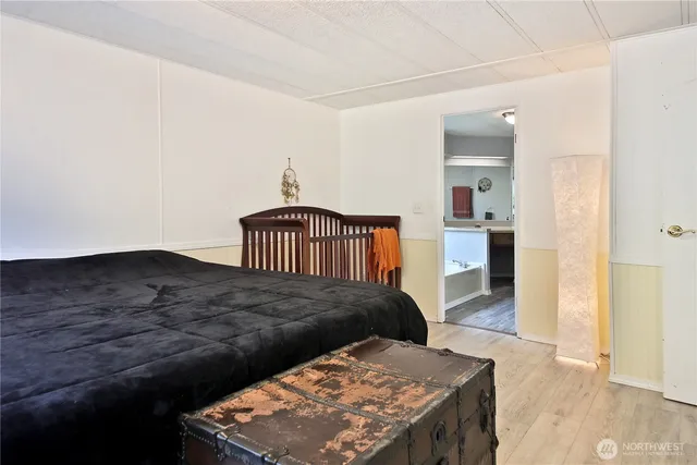 a bedroom with a bed and wooden floor