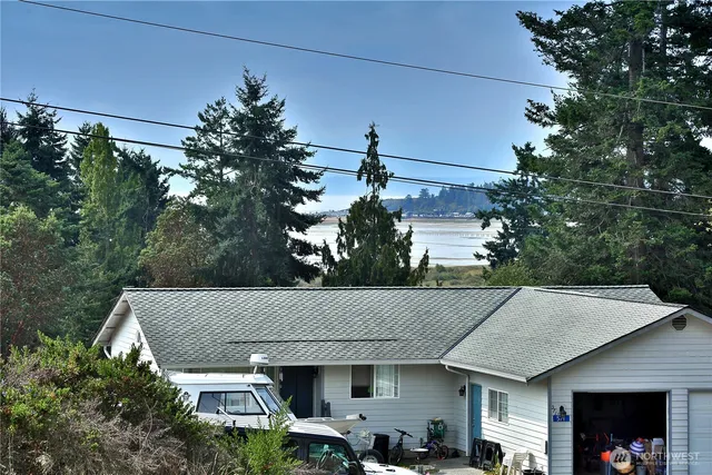 a view of a white house next to a yard