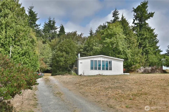 a front view of a house with a yard and trees