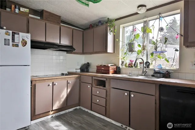 a kitchen with stainless steel appliances granite countertop a sink a stove and a microwave