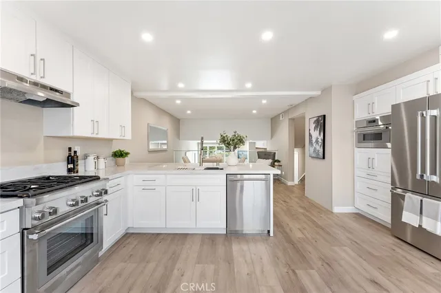 a kitchen with white cabinets and stainless steel appliances